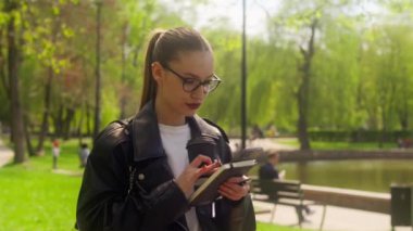 Kafkas kadın iş kadını cep telefonu akıllı telefon teknolojisi kullanıyor. İnternette çalışıyor. Kahve içiyor, parkta yürüyor.