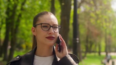 Kafkasyalı mutlu bir kadın cep telefonuyla konuşuyor. Konuşuyor, dedikodu yapıyor. Kız gülümsüyor.