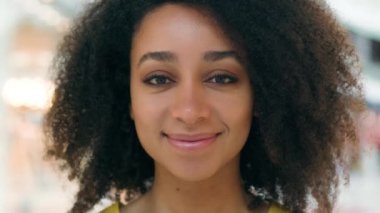 Yüzü kapatın neşeli Afro-Amerikalı kadın gülümseyen alışveriş düşkünü kadın kozmetik surat ağızları kameraya bakıyor iyi bir tatil makyajı zevkli bir kız portresi