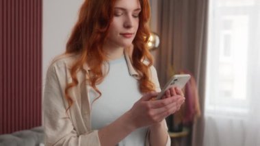 Kaygısız, beyaz kadın, kadın, gülümseyen, dokunmatik, akıllı telefon mesajı. Rahat 20 'li yaşlardaki kız modeliyle çevrimiçi sosyal medya bağlantısı kurmak için ağ uygulaması e- posta mesajları kullanıyor.