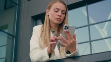 Düşünceli beyaz kadın işveren parşömen cep telefonu bilgi mesajını okuyor. Düşünceli iş kadını kadın patron sorunlu kız akıllı yönetici arama çözümü şehir balkonu.