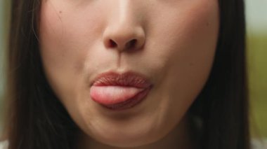 Son derece yakın detaylar, tanınmayan Asyalı bir kadının ağzı, buruşuk dilli bir kızın ağzı dişlek, dişlek, tıbbi sağlık hizmetleri kozmetik güzellik prosedürü, cilt bakımı, dudak dolgusu.