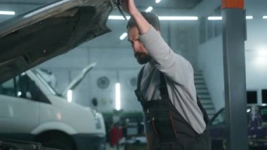 Kafkas erkek tamirci, teknisyen, elektrikçi, üniformalı sanayi işçisi, otomobil mühendisi, kaput kaputu açık, motor tamiri, garaj tamirhanesinde tamirat.