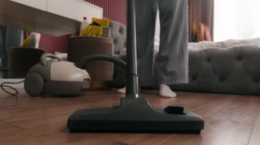 Elektrikli süpürge ile yerleri süpüren tanınmayan bir kadın. Yorgun bayan ev hanımı. Ev sahibi, ev temizlikçisi.