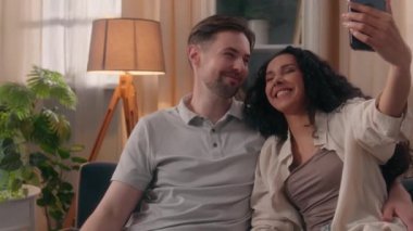 Mutlu aile çifti gülümseyen nüfuzlu kişiler, video kaydediciler, beyaz erkek, koca, Latin kadın, kadın, video konferans, cep telefonu uygulaması.