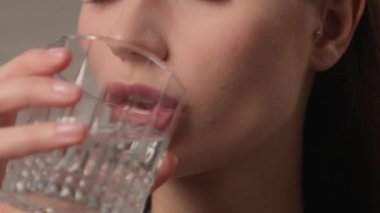 Susamış Kafkasyalı kadın kadın yeni güne sağlıklı bir alışkanlıkla başlıyor. Bardak tutuyor, temiz mineral içiyor, durgun su içiyor gülümsüyor, hayat tarzı gülümsüyor, sağlık hizmeti içeceği içiyor.