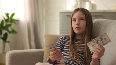 Küçük Avrupalı kız dolar sayıyor faturalar para finansman çocuk para para döviz yüz tasarruf servet bütçe banknotları kız kadın bankanın ekonomik gelir ödemesi maaş satın