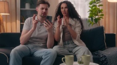 Komik bir aile çifti, erkek, erkek, erkek, erkek, Latin, kadın, kız, kız, kız, parmaklarını çaprazlayarak umarım cep telefonu kazanır.