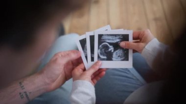 Tanımlanamayan hamile çift, klinikteki sağlık sigortası ebeveynleri erkek, baba, kız anne, ultrason görüntülerini taşıyor.