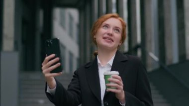 Başarılı bir şekilde gülümseyen Kafkas kızılı iş kadını bayan bayan bayan öğrenci öğrenci konuşmasına internet üzerinden mobil toplantı konferansını açık havada kahve molası vererek anlatın.