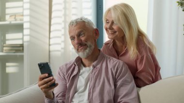 Neşeli, yaşlı, yaşlı, yaşlı bir çift cep telefonu hakkında konuşuyor, erkek, kadın, video, kadın, karı, koca, bloglar yazıp, el sallayarak sınıf içinde selamlaşıyorlar.
