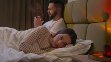 Kafkas kadın kız arkadaşı yatakta yatıyordu. Erkek arkadaşı geri çevrildi. Cep telefonu, akıllı telefon, tatminsiz ilişki, ilgi bağımlılığı.