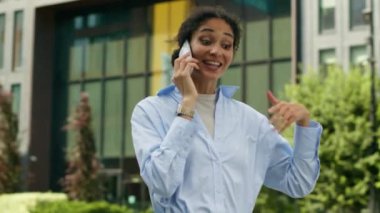 Mutlu gülümseyen cep telefonları dostça sohbet akıllı telefon Afrikalı Amerikalı öğrenci kız girişimci kadın iş kadını şehir dışında yürüyüp giden bayan iş kadını