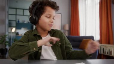 Afrika kökenli Amerikalı küçük oğlan bebek kulaklıklı çocuk müzik dinliyor, müzik dinliyor, müzik dinliyor, şarkı söylüyor, dans ediyor, gülümsüyor, el ele tutuşuyor, eğleniyor, eğleniyor.