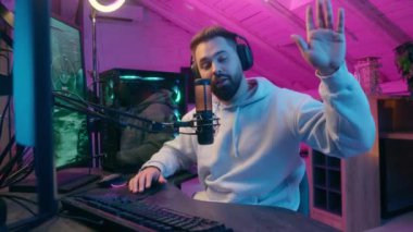 Beyaz tenli gülümseyen mikrofon kameraman erkek oyuncu flamalı flama etkili blogcu kulaklık kayıt kanalı online vlog sohbet e-spor video oyunu siber spor radyo sunucusu