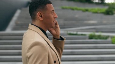 Afro-Amerikan erkek girişimci işadamı şehir işadamı ofis binasında yürüyen iş adamı hareket halindeki cep telefonu konuşmaları akıllı telefon konuşmaları sohbet konuşmaları