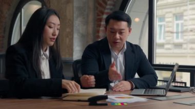 Kötü iş sonucu, ofisteki iki iş arkadaşı memnun olmayan CEO patron Asyalı iş adamı Koreli işadamı laptop belgelerine işaret ederek konuşuyor.