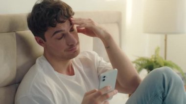 Kafkas Avrupalı erkek yatak odası yorgun erkek aşırı çalışan cep telefonu akıllı telefon online iş telefonu teknoloji girişimcisi yorgun serbest girişimci uykulu iş hüsranı