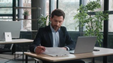 Başarılı Kafkasyalı iş adamı, iş adamı, erkek ofis çalışanı, muhasebeci, yönetici, girişimci, girişimci, muhasebe notları hazırlıyor. Laptop üzerinde çalışan bilgisayara veri girin.