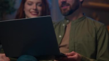 Yakın plan gülümseyen Kafkasyalı bir aile evli karı koca video konuşmaları yapıyorlar. Ev hanımları dizüstü bilgisayarlarıyla el sallıyorlar. İnternetteki sanal konferansta iletişim kuruyorlar.