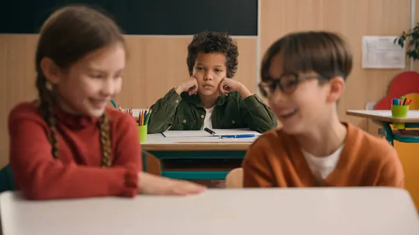 İki Kafkas çocuk okulu kız sınıf arkadaşı gülüyor kötü kahkahalar atıyor zorba Afrikalı Amerikalı çocuk okul çocuğu üzgün üzgün üzgün yalnız alay eden çocuklar sınıf ayrımcılığı