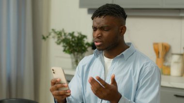Afro-Amerikalı erkek çift ırklı erkek kullanıcı evde öfkeli öfkeli kötü SMS haber aygıtı sorunu cep telefonu kayıp uygulama hatası akıllı telefon olumsuz mesaj rahatsız edici çöp posta