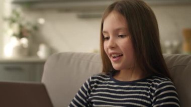 Kafkasyalı küçük kız öğrenci kız öğrenci çocuk dölü dizüstü bilgisayarı kullanıyor. Bilgisayarda eğitim veriyor. Gülümseme, keyif iletişimi, internet üzerinden SMS teknolojisiyle sohbet ediyor.