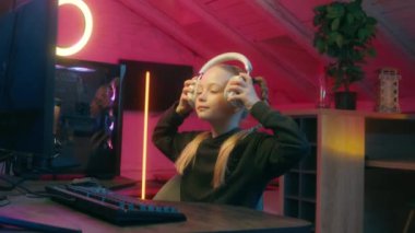 Kafkasyalı küçük kız çocuk kulaklık takıp video oyunu oynamaya hazır ol mikrofon internet bilgisayarı bağımlısı online sanal spor blogcusu vlogger etkili akış