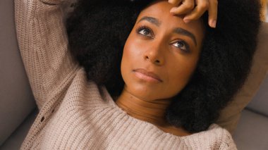 Yalnız üzgün, üzgün Afrikalı Amerikalı kadın evde yalnız başına yatıyor mutsuz, ilgisiz, tembel kadın kanepe depresyonunda dinleniyor. Psikolojik sorunlardan muzdarip.