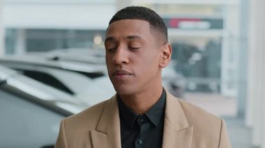 Afro-Amerikalı adam düşünceli, düşünceli, kararsız, etnik erkek, müşteri, otomobil galerisinde araba seçen işadamı, otomobil taşımacılığını seçiyor, zor bir karar verme sorunu düşünüyor.