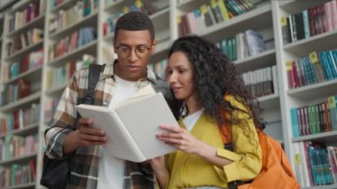 Heyecanlı Afrikalı Amerikalı erkek Latin Arap kadın kitap topluluğu kitapları okuyor kitapçıda ilginç bir hikaye birlikte eğitim öğreniyorlar kadın edebiyat istihbarat kitaplığı projesi