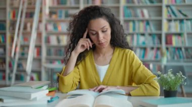 Latin Latin kadın kitap öğrenme sınavı hazırlıyor. Kapalı ders kitabı okuyor. Bayan eğitimi, ev ödevi, sıkıcılık.