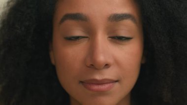 Kapalı yüzlü Afro-Amerikalı kadın, koyu renk gözleri kapat, kameraya bakan iş kadını, güzel bayan, doğal makyaj, sağlıklı cilt sağlığı reklamları.