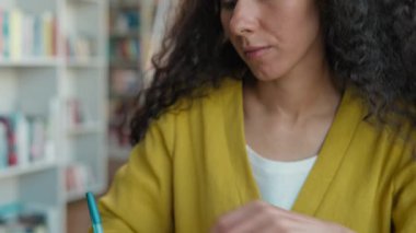 Not defterine yazı yazan Latin Arap bir kadın, ilham yazarı, el yazısı yazarı, gazeteci edebiyatı, yaratıcı yazarlık, kitap eğitimi gibi konulardan ilham alarak sınav görevine hazırlanır.