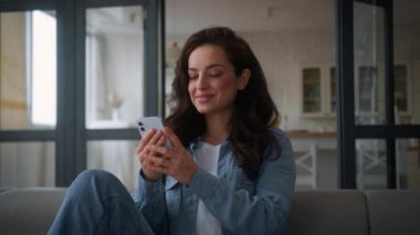 Kafkasyalı Avrupalı kadın kullanıcı, kanepe koltuğunda, cep telefonu sohbeti yapan, erkek arkadaşıyla kucaklaşan, akıllı telefona sarılan, sohbet eden, cep telefonu alışverişi yapan, internet üzerinden rüya gören internet uygulaması.
