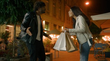 Alışveriş çantalı, sinirli, saldırgan, etnik Arap bir çift. Yanak kavgası yapan bir kadın. Yüzüne tokat yiyen bir adam.