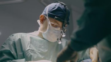 Üniformalı iki doktor, doktor, doktor, cerrah, tıp hemşiresi hastane kliniğinde acil ameliyat, estetik cerrahi nakli, hasta sağlığı için tıbbi yardım operasyonu gerçekleştiriyor.