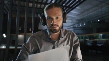 Gece Ofisi Kafkasyalı internet öğretmeni uzak koç Kafkasyalı iş adamı kulaklıklı kağıt belgeleri kamera konferansında konuşma video görüntüleme uzmanına danış.