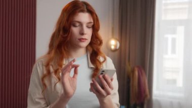 Kafkasyalı kadın üzgün, ekranda kayan, cep telefonu taşıyan, üzgün kadın, kötü bilgi sorunu, endişeli model, evde onaylanmamış hareket yok.