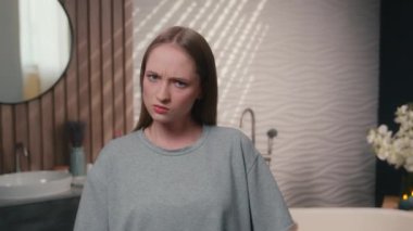 Ev tuvaletindeki kadın portresi üzgün, gücenmiş kadın, beyaz kadın ev sahibi ciddi şekilde üzgün, suratsız, suratsız, suratsız, sinirli, karamsar, karamsar.