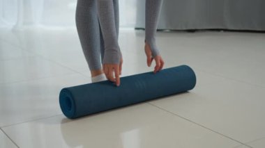 Tanımlanamayan bir kadın yoga minderini Yogi fitness eğitmeni spor sporcusu bir kız spor egzersiz jimnastik ekipmanında sağlıklı sabah meditasyonuna kadın ayaklarıyla başlar.