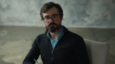Dikkatli, ciddi, orta yaşlı, erkek psikolog, gözlüklü, psikoterapist, hastayı dinleyen, not yazan müşteriler. Pano danışmanlık hizmeti kabinesi
