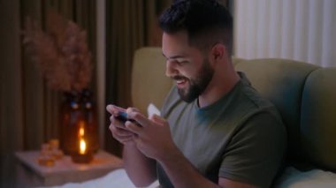 Heyecanlı Kafkasyalı adam cep telefonu akıllı telefon oyunu oynuyor duygusal erkek adam gergin ev eğlencesi aleti teknolojisi bağımlısı rekabetçi eğlence oyuncusunun online turnuvası