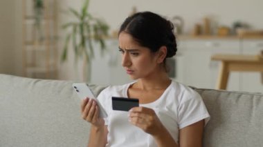 Kafası karışmış Hintli kadın Arap bayan sorunlu cep telefonu. İnternetten alışveriş kredisi satın almaya çalış. Engellenmiş banka kartı internet uygulaması.