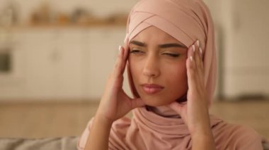 Hüzünlü portre, kötü kötü duygular, kötü hüzünler, Hintli Arap kadın, Müslüman kadın, evde tesettüre girmiş kadın, baş ağrısı, baş ağrısı, baş ağrısı, sağlık sorunları.