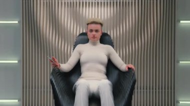 Kafkasyalı kadın oyuncu kullanıcı programcısı kadın hacker iş kadını siyah koltukta oturuyor fütürist stüdyo siber güvenlik modern yenilik cep telefonu kendine güvenen iş kadını kameraya bakıyor