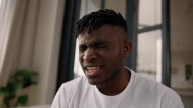 Afrika kökenli Amerikalı erkek, kızgın, deli deli adam, evde kriz krizine bağırıyor, strese giriyor, olumsuz duygular haykırıyor kameraya öfkeli çığlıklar atıyor, sinirden kuduruyor.