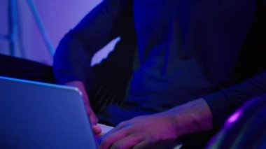 Hacker internete girip bilgisayar fütüristik siber uzay oyuncusunu araştırıyor kulaklıklı Afrikalı Amerikalı adam dizüstü bilgisayarı yazıyor internet güvenliği hackliyor video oyunu yenilikçiliği yapıyor koltukta