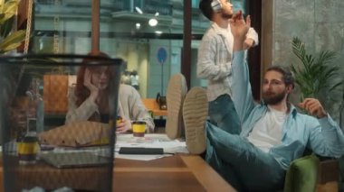 Grup iş ortaklığı ofis ekibi, erkekler, kadınlar, kız erkekler, kadın iş arkadaşları, serbest iş arkadaşları, yaratıcı öğrenciler gazete fırlatmak, kahve içmek, eğlence, sıkıcı iş tembelliği.