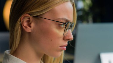 Kendine güveni tam bir kadın portresi. Yan tarafa bakıyor. Gözlüklü, ofis şirketinde çalışan gözlüklü, beyaz iş kadını iş kadını tasarımcı.